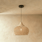 Clérachic natural rattan pendant light with a beige teardrop cage shade and wood cap suspended from a black cord.