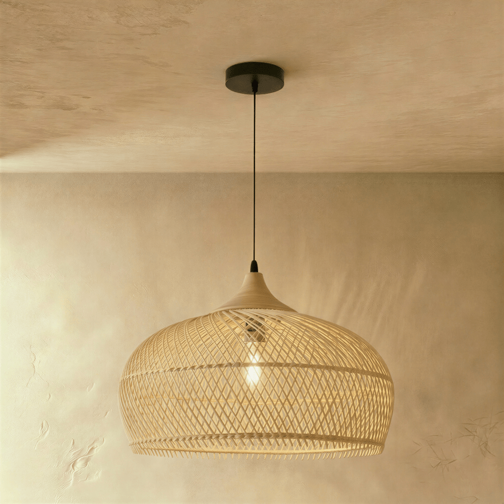 Clérachic natural rattan pendant light with a rounded beige dome shade and wood cap hanging against a plaster wall.