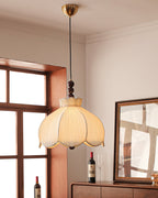 Clérachic pendant with a brass canopy, beige pleated shade and walnut beads, hanging by a window and a framed mirror.