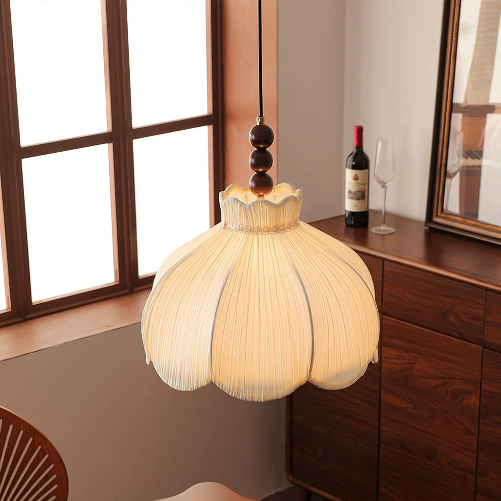 Clérachic beige pendant with a scalloped neck, hanging beside a wood-framed window and a walnut cabinet.