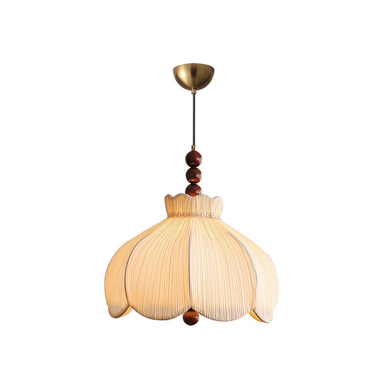Front view of this Clérachic pleated pendant on a brass canopy, with scalloped petals and walnut beads, on white.