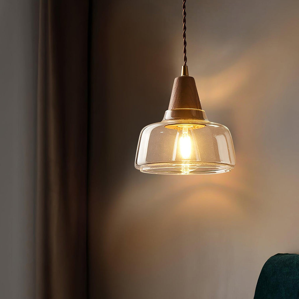 The Clérachic wall sconce casts a warm glow beside a herringbone curtain and dark leather sofa in a cozy living room.