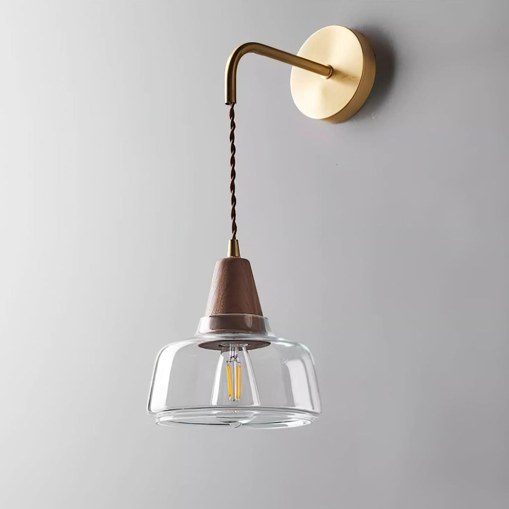 Clérachic bell glass sconce shown straight-on against plain gray, highlighting the brass ferrule and visible filament bulb.