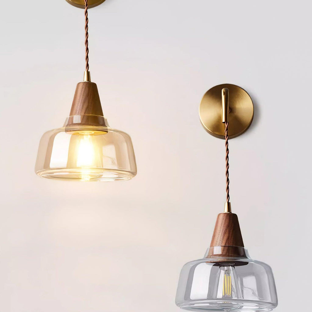 Two Clérachic bell glass sconces mounted side by side on a gray wall, one lit and one unlit, showing the pair together.
