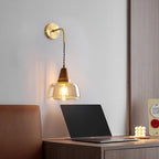 Clérachic sconce lighting a home desk setup with an open laptop, leather chair and a small candle nearby.
