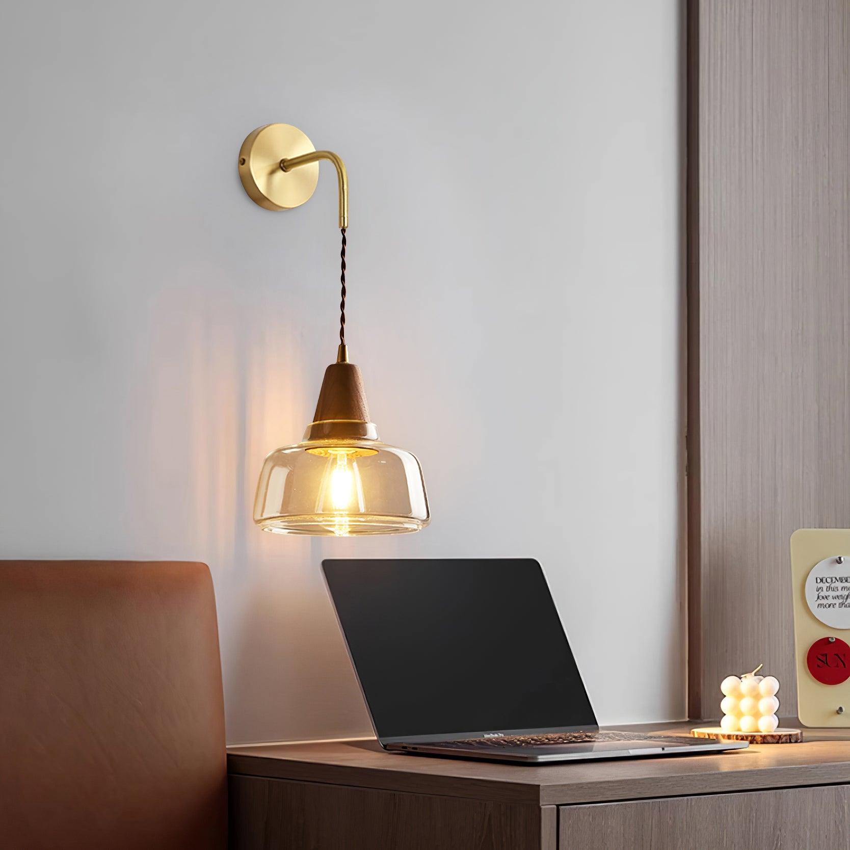 Clérachic sconce lighting a home desk setup with an open laptop, leather chair and a small candle nearby.