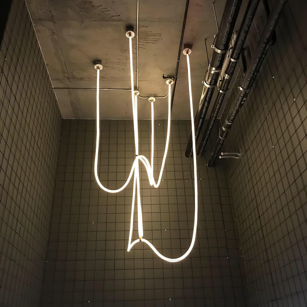 Clérachic LED rope pendants hanging in tangled, looping lines against a dark tiled wall, seen from below.