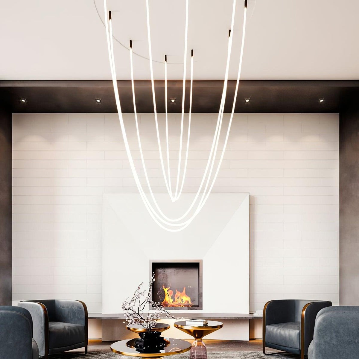 Long, parallel Clérachic LED rope pendants over a white fireplace wall, with two dark armchairs and a gold side table below.