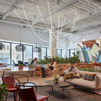 Clérachic LED rope pendants spread across a high ceiling above a lounge with plants, rattan pendants and a mural.