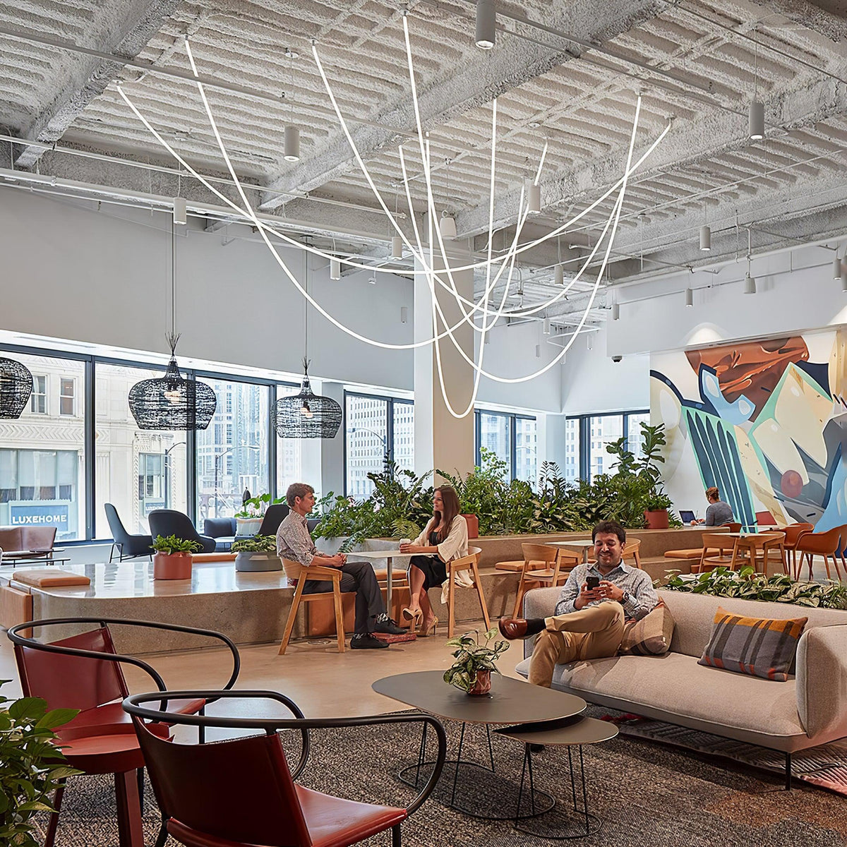 Clérachic LED rope pendants spread across a high ceiling above a lounge with plants, rattan pendants and a mural.