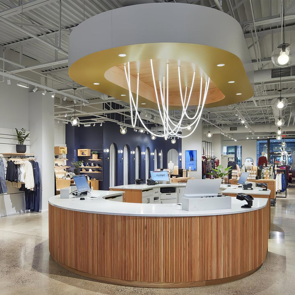 Clérachic LED rope pendants forming a glowing cluster in a shop's gold ceiling feature, above a round wooden counter.