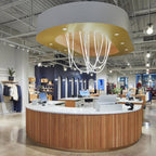 Clérachic LED rope pendants forming a glowing cluster in a shop's gold ceiling feature, above a round wooden counter.