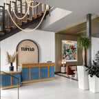 Clérachic LED rope pendants in a hotel entrance, curving over a stair with a blue reception desk and an arched sign on the wall.