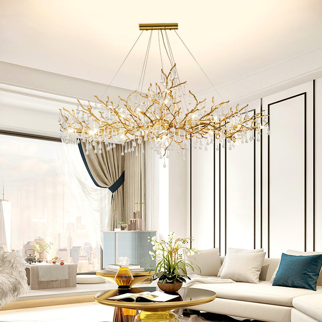 Clérachic Bijou chandelier lit in a bright living room above a cream sofa and a city window.