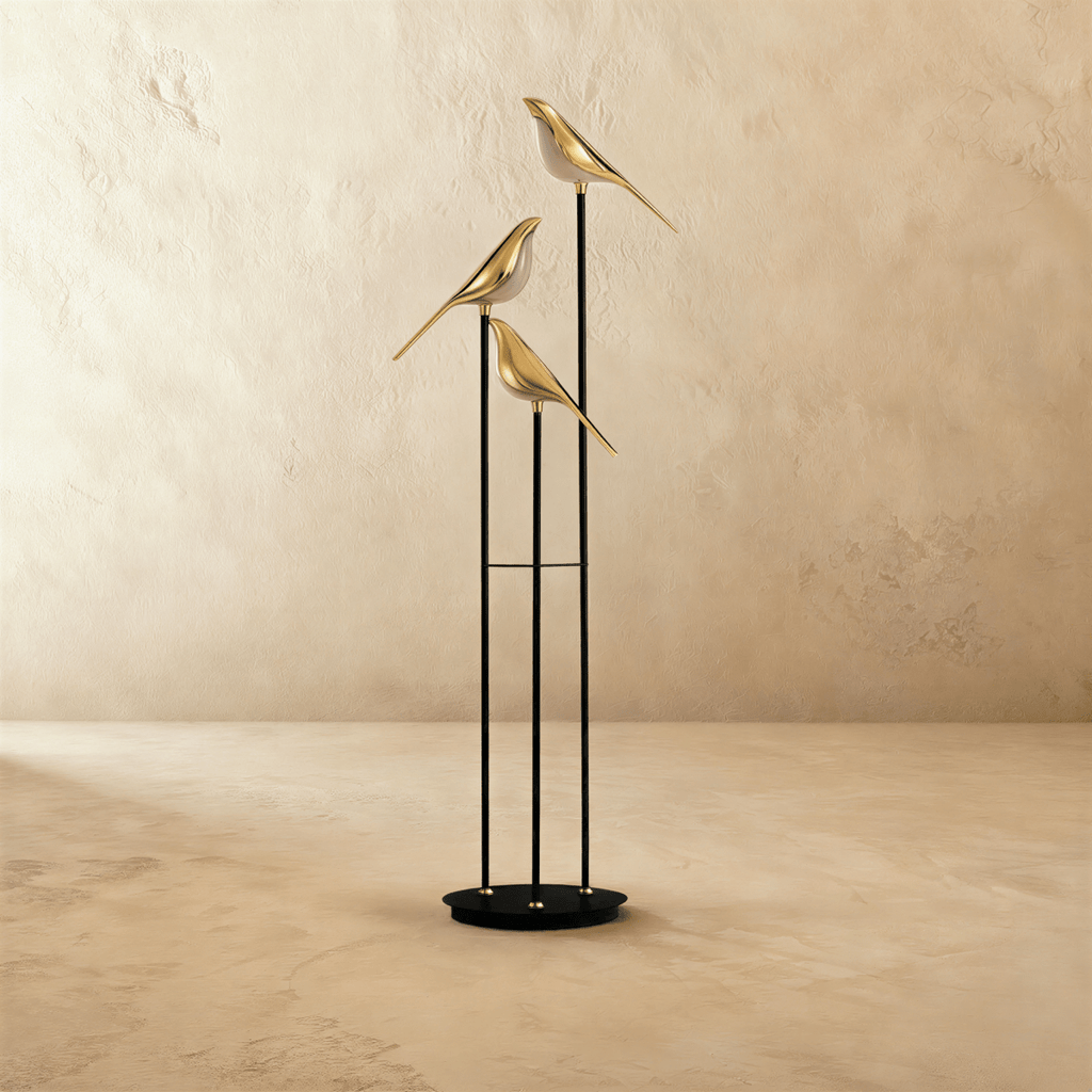 Clérachic three-head floor lamp with gold-finish bird shades on black stems and a round base, switched off on a limewashed floor