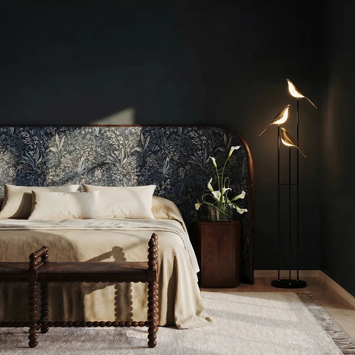 Clérachic three-head bird floor lamp glowing beside a bed with a patterned headboard against a dark wall