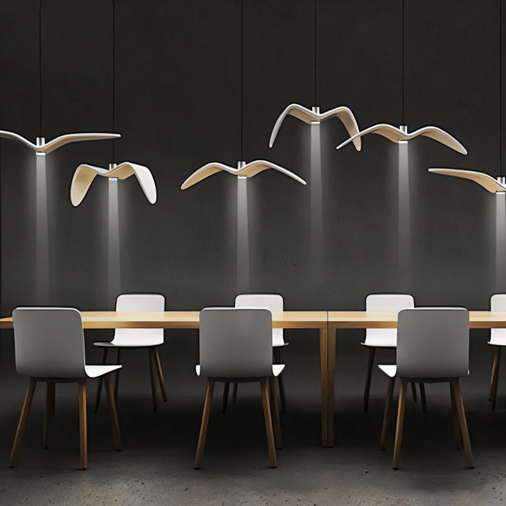 Clérachic white gull-winged pendants hung at varied heights over a long timber table, each casting a narrow downward beam.