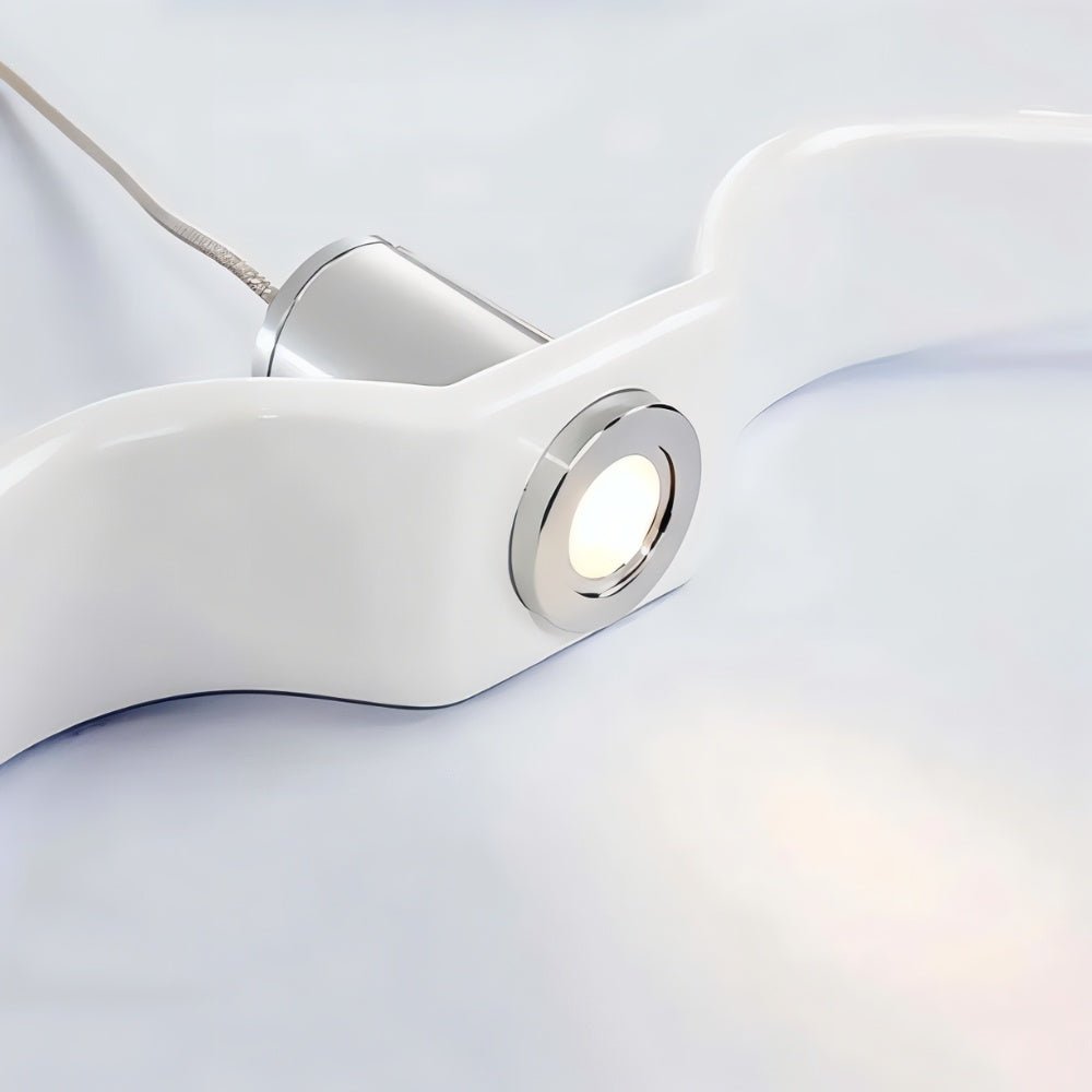 Clérachic close view of a glossy white winged pendant body, its chrome-ringed warm spotlight and aluminium cylinder on a pale ground.