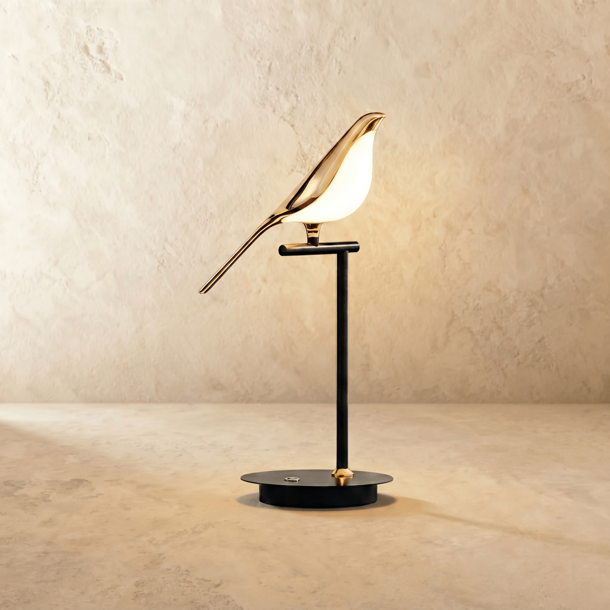 Clérachic one-head bird table lamp with a gold-finish bird and glowing acrylic body on a black stem and round base.