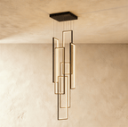 Clérachic black stairwell chandelier with six slim LED frames at staggered heights, hung from a square canopy on a plaster wall.