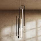 Clérachic black rectangular LED frames, four in a staggered stack, seen close up against a warm textured wall.