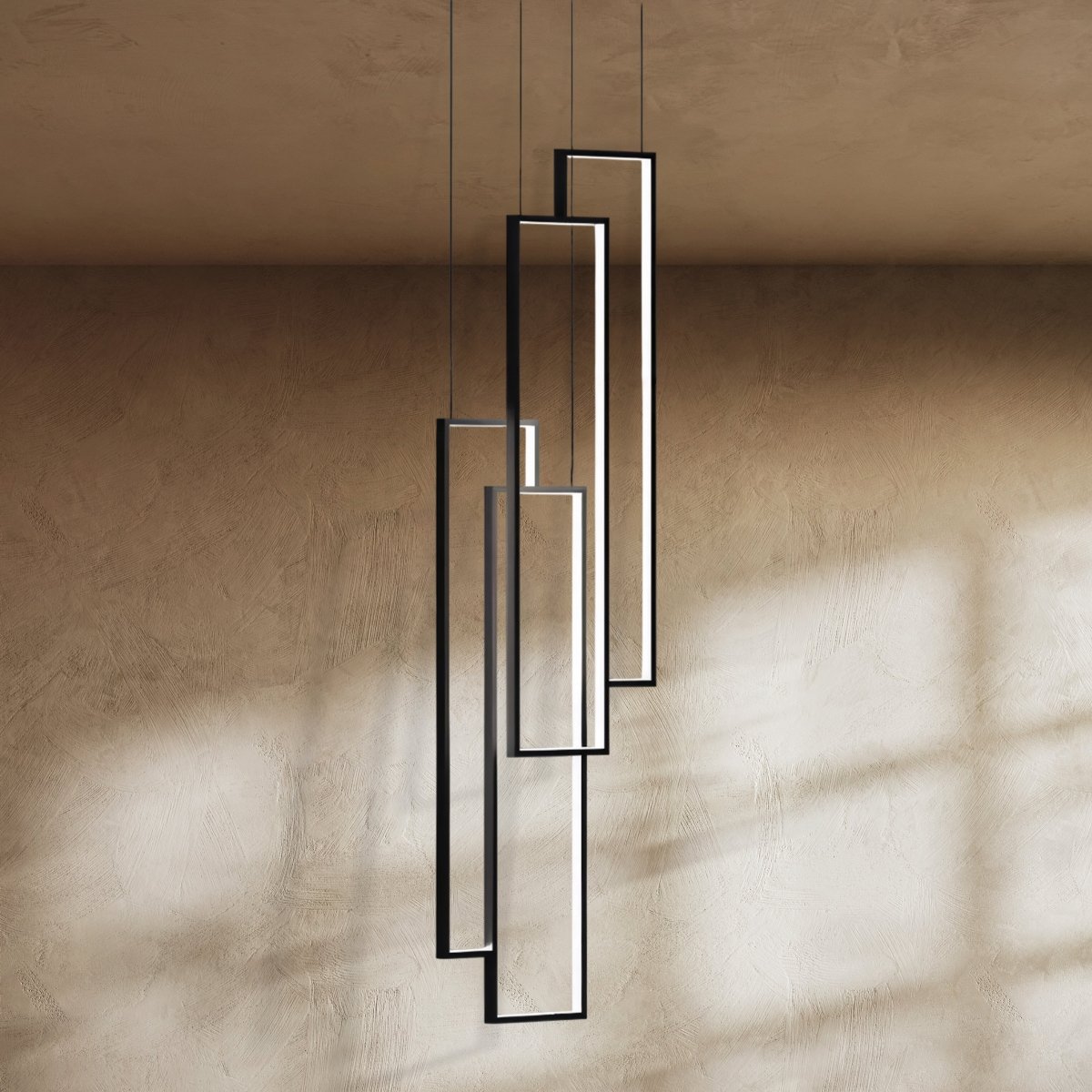 Clérachic black rectangular LED frames, four in a staggered stack, seen close up against a warm textured wall.