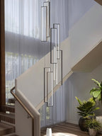 Clérachic black and white rectangular LED frames at staggered heights, hung beside a staircase with sheer curtains behind.