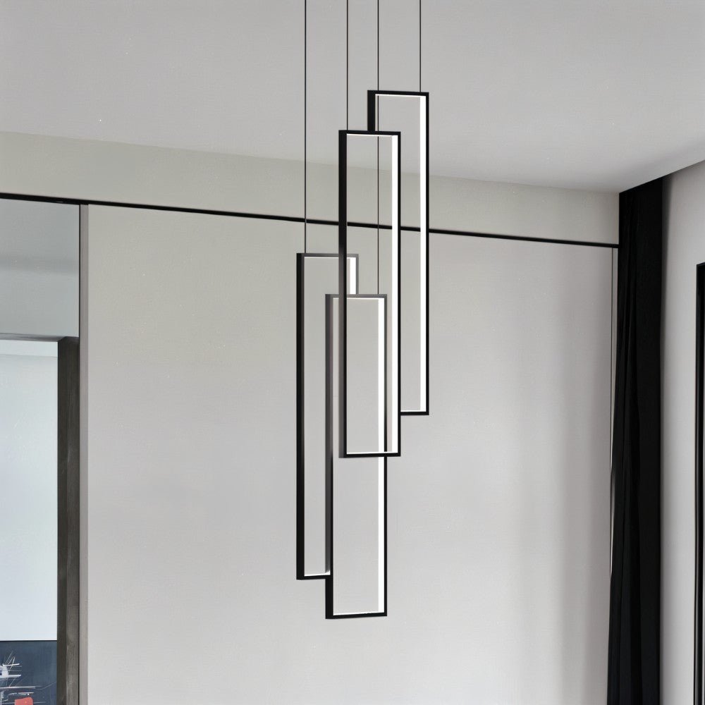 Clérachic four slim black rectangular LED frames at different heights, hung on thin cables against a pale grey wall.