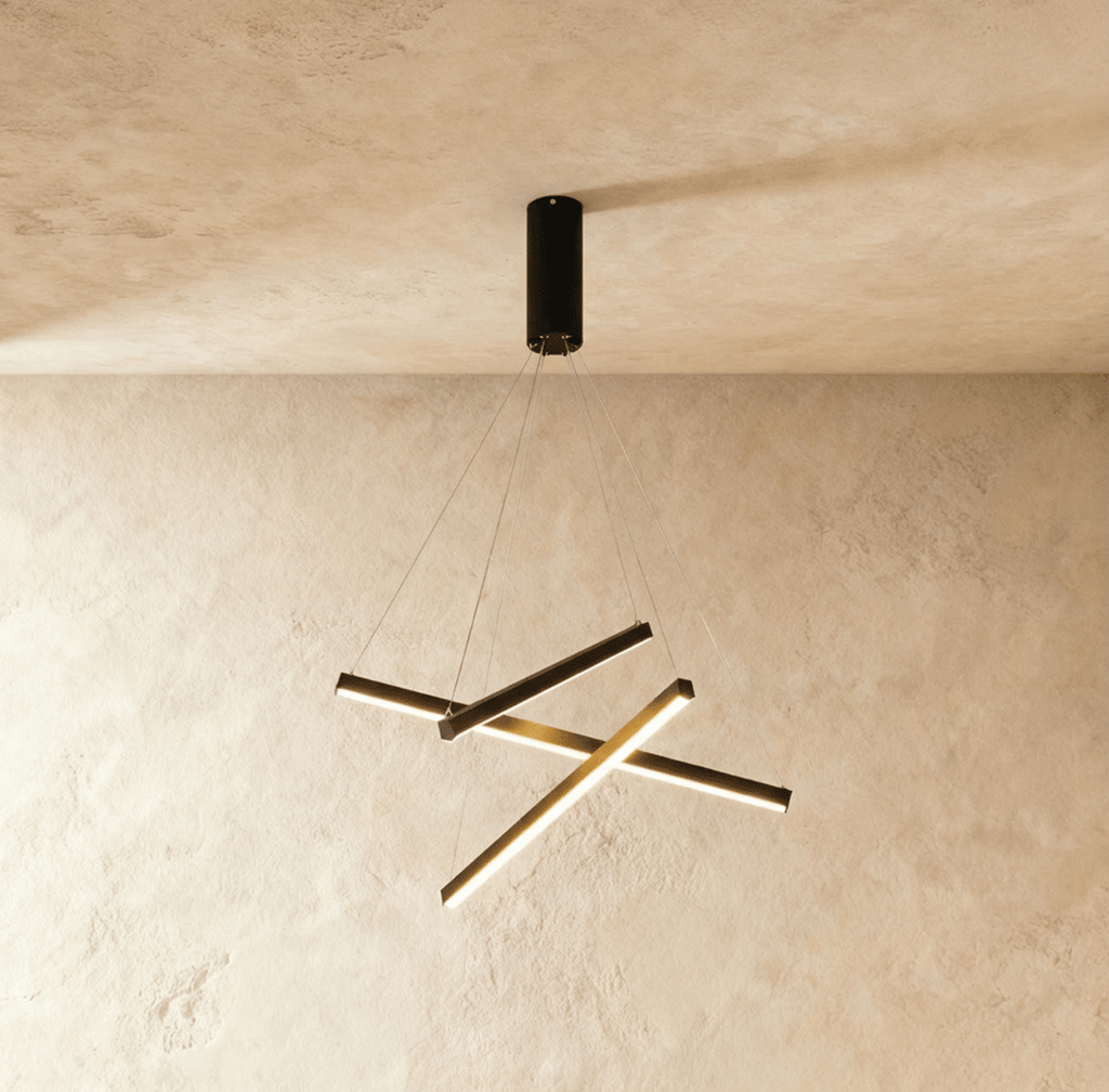 Clérachic black aluminium staggered-bar chandelier, its crossed LED strips glowing warm white below a round ceiling mount.