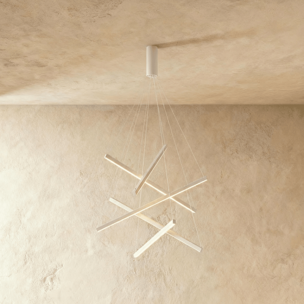 The Clérachic white chandelier with five crossed aluminium bars, each glowing warm white, hanging on fine support cables.
