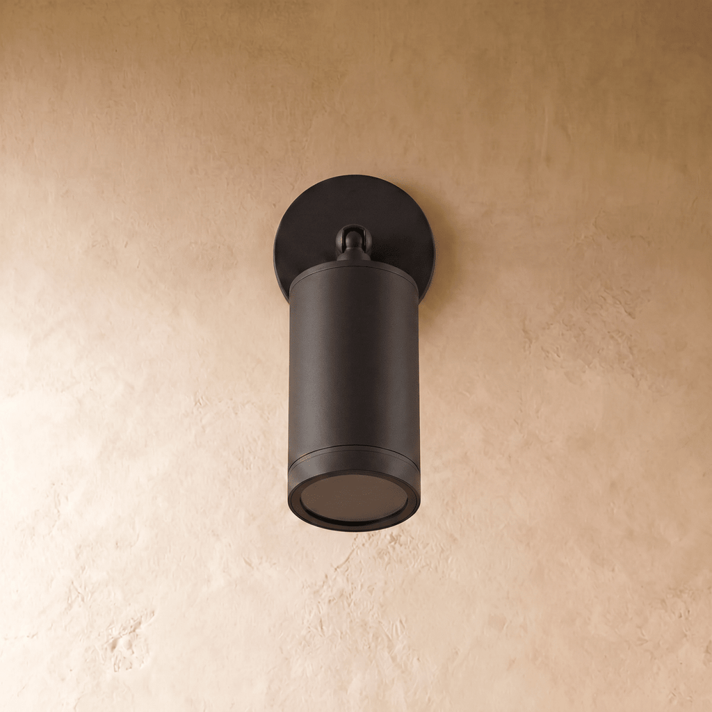 Clérachic black aluminium wall spotlight switched off, showing the matte cylinder, ball joint and dark lens on plaster.