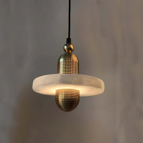 Clérachic black and gold pendant light, single alabaster disc on ribbed gold hardware, glowing on a white studio ground.