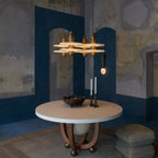 Clérachic gold double-disc pendants cluster over a round white table in a blue-plaster dining room.