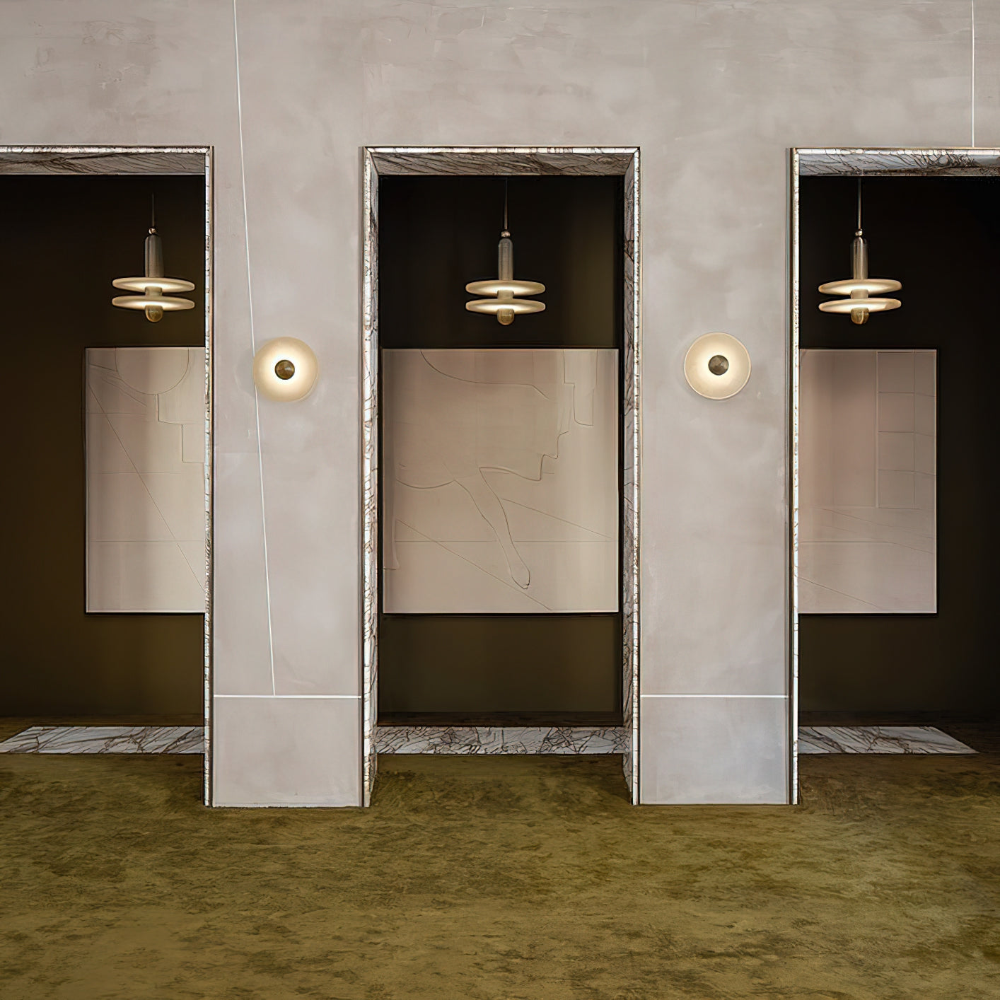 Clérachic gold double-disc pendants hang in marble-framed doorways along a green-carpeted gallery hall.