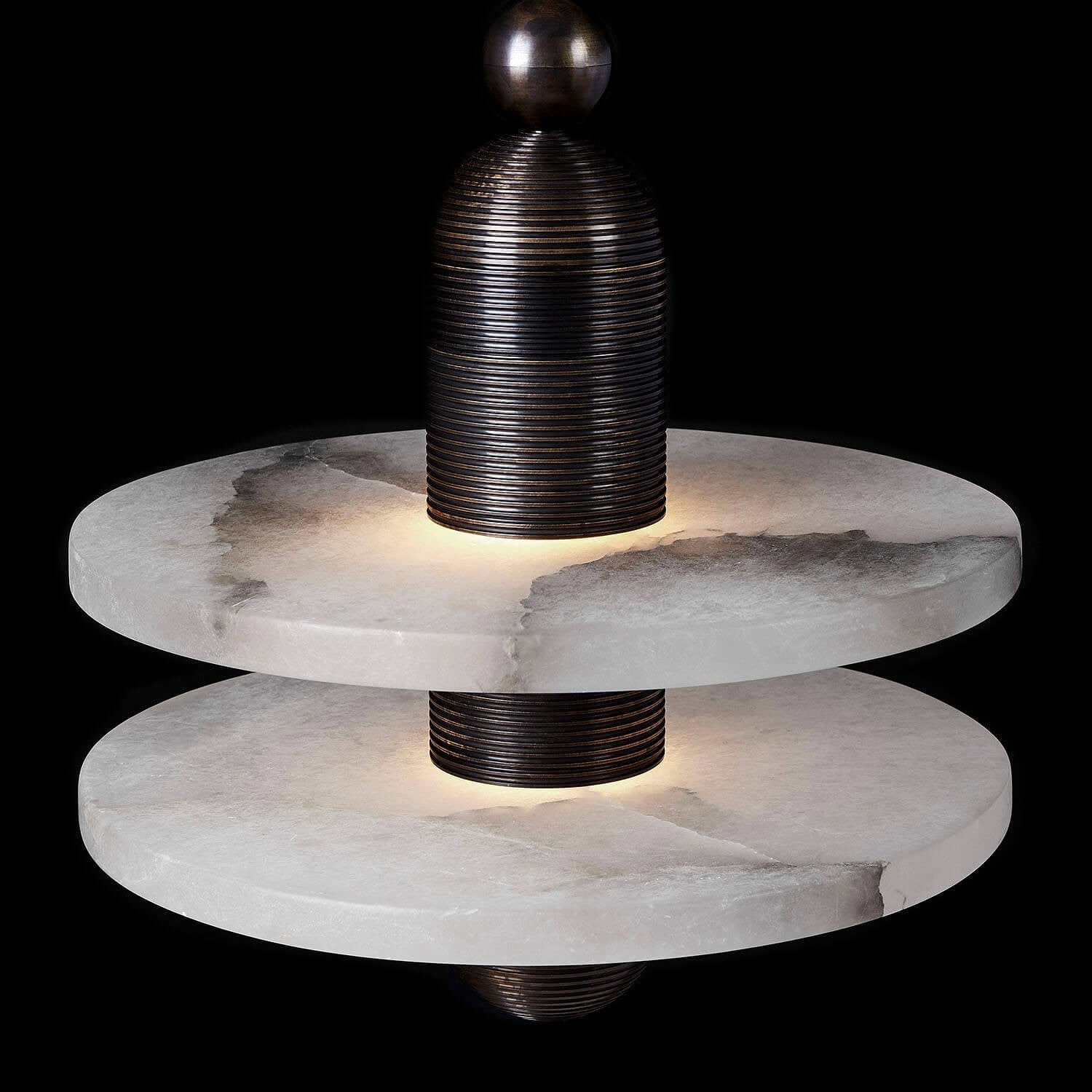 Clérachic black double-disc pendant in close-up, warm LED at each alabaster plate against a dark ground.
