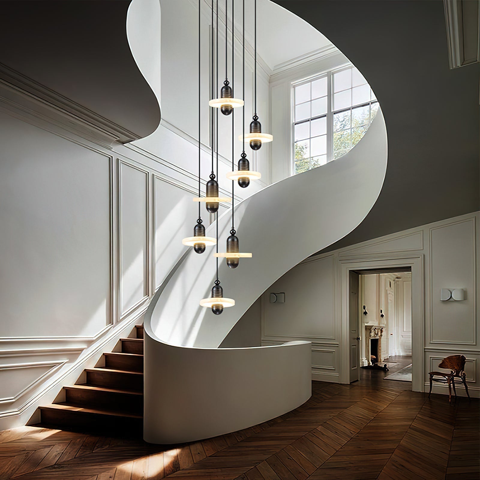 Clérachic black single-disc pendants drop seven-high through a white spiral stairwell over herringbone floors.