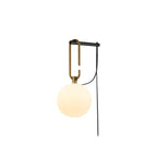 A Clérachic wall lamp with a warm cream globe on a gold loop and black bar, with its black cord, on a white background.