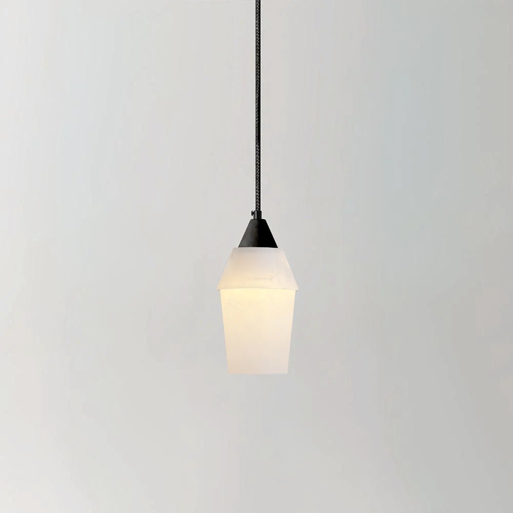Lit studio view of the Clérachic Black and White Alabaster Pendant Light, tapered white shade and black cap on grey.