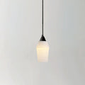 The Clérachic Black and White Alabaster Pendant Light hangs lit on a grey ground, warm glow through the tapered stone.