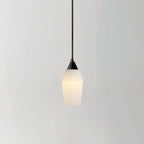 The Clérachic Black and White Alabaster Pendant Light hangs lit on a grey ground, warm glow through the tapered stone.
