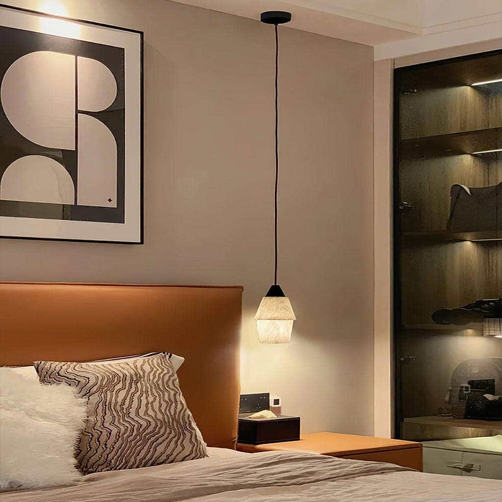 Clérachic Black and White Alabaster Pendant Light hangs as a bedside lamp by a tan leather headboard and glass wardrobe.