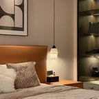 Clérachic Black and White Alabaster Pendant Light glows amber beside a cognac headboard, wavy pillow, and lit closet.