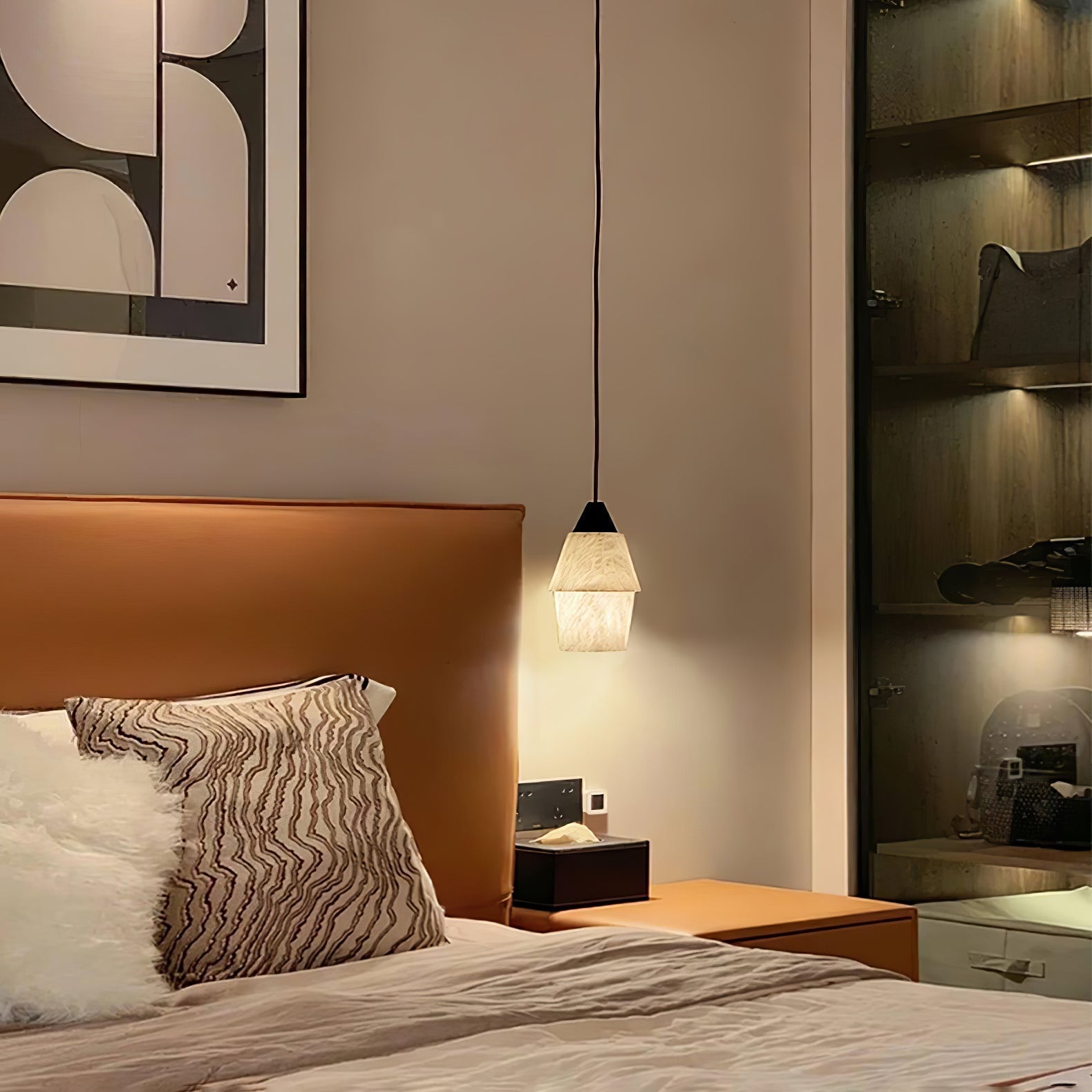 Clérachic Black and White Alabaster Pendant Light glows amber beside a cognac headboard, wavy pillow, and lit closet.