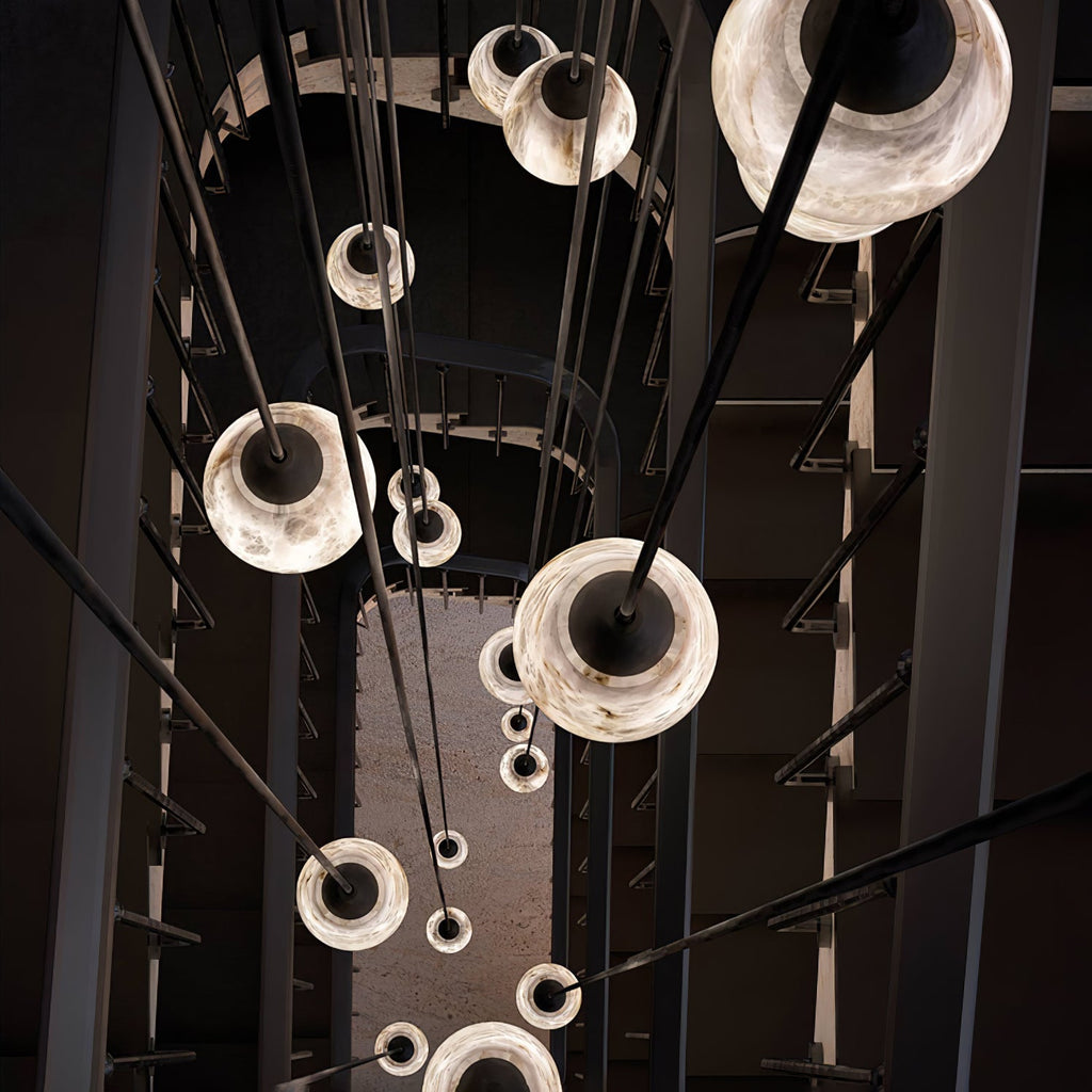 Clérachic Black and White Alabaster Pendant Lights recede toward the floor of an industrial stairwell on long black rods.