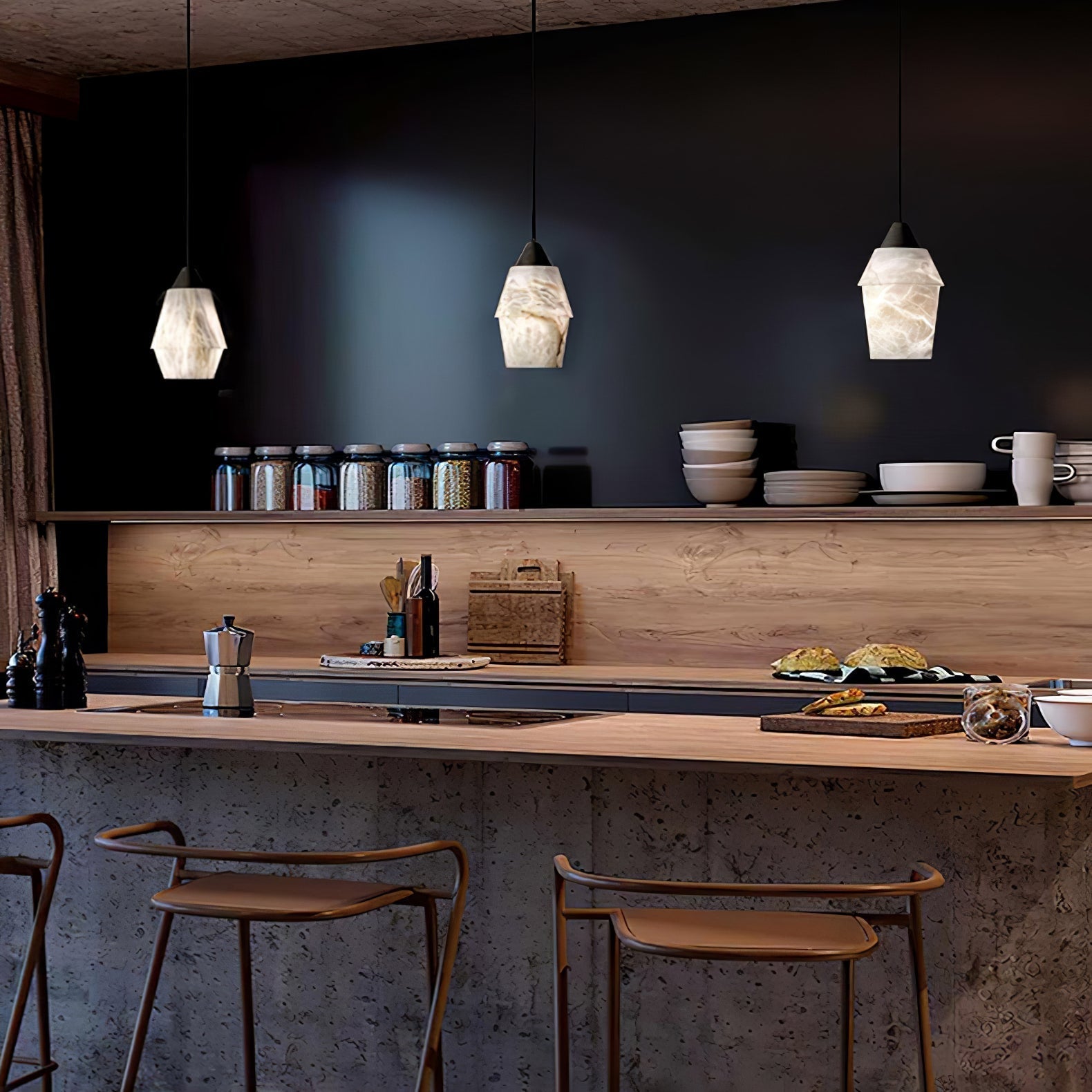 Three Clérachic Black and White Alabaster Pendant Lights hang over a thick wood bar, jars lining the black kitchen wall.