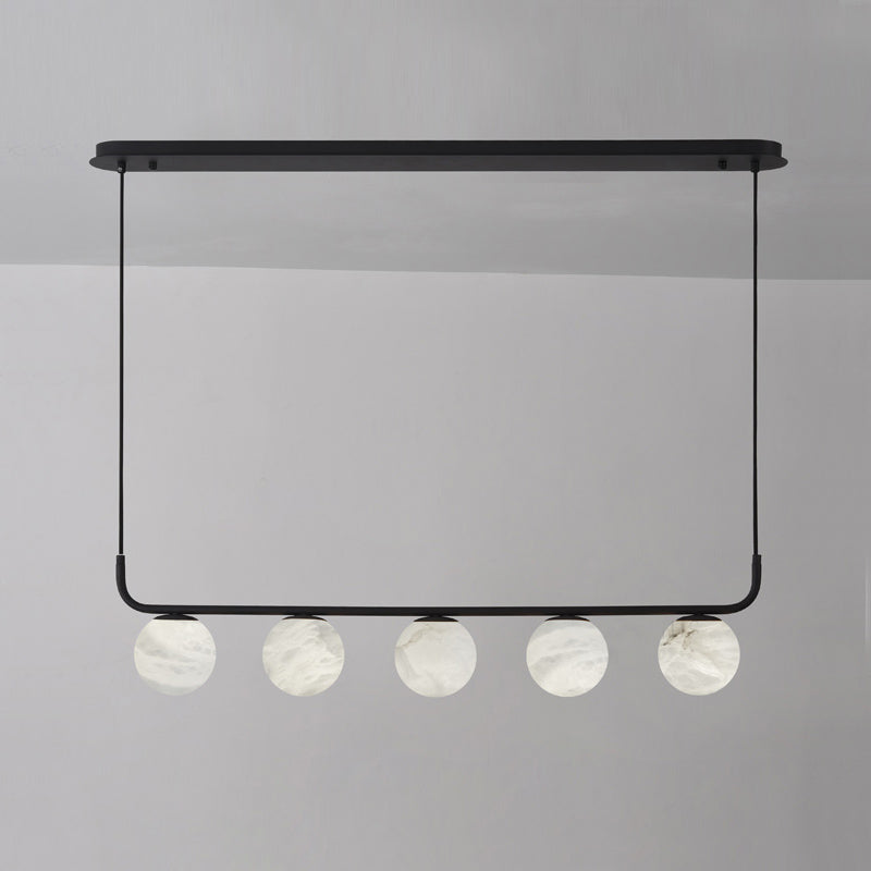 Five alabaster globes in a straight line on the Clérachic black bar pendant, photographed unlit against a soft grey wall.