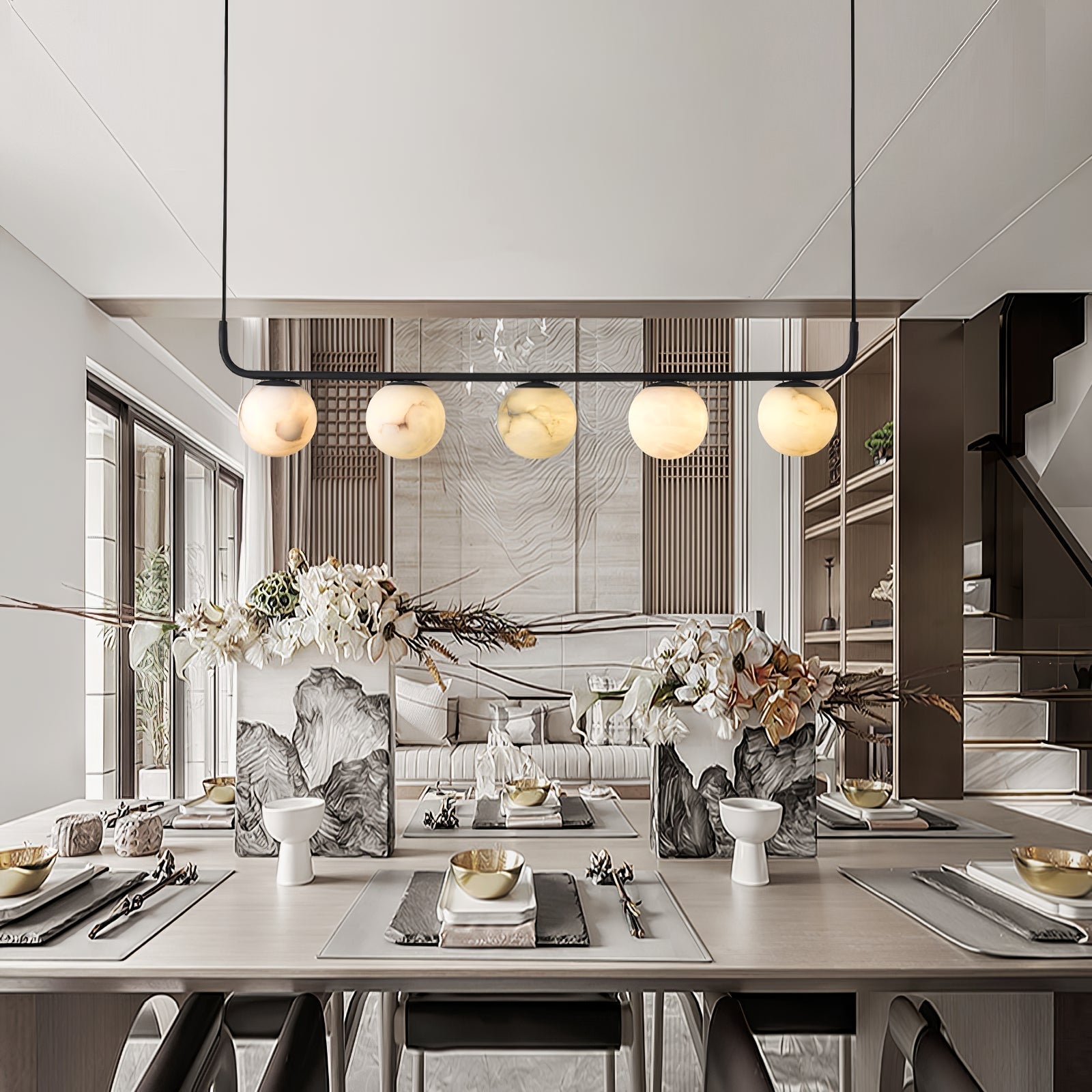 The Clérachic five-globe bar warming a set dining table, its light landing evenly along the length of the setting.
