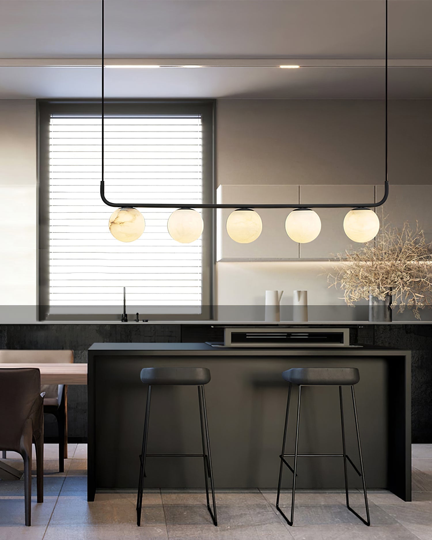 The Clérachic bar pendant above a dark kitchen island, globes catching daylight from the shuttered window behind.