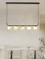 The Clérachic pendant hung from its oval ceiling plate in a bright room, five globes over a marble table.