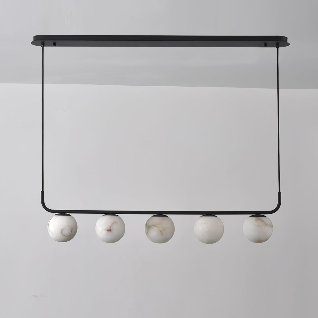 The Clérachic five-globe bar straight on and unlit, cool white stone with soft grey-brown veins against a grey wall.